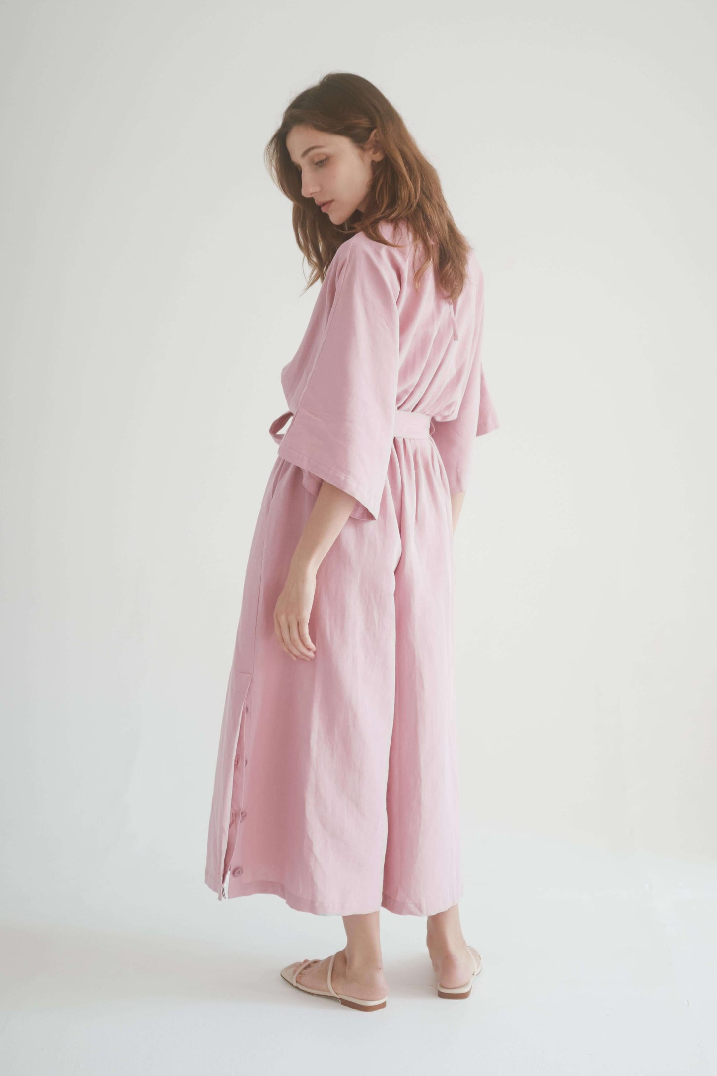Model wearing a rose kimono jumpsuit with elasticated waist and side pockets, showcasing its stylish and versatile design.
